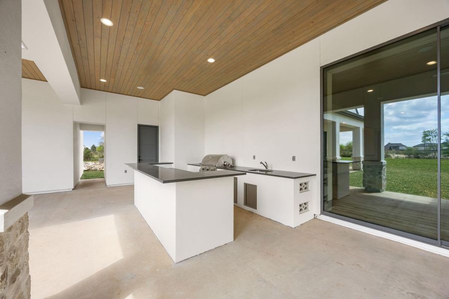Another view of rear loggia showing outdoor kitchen. The grey door is the pool bath entrance from outside for a future pool. Bath can also be accessed from in to game room/bowling alley. Another view of rear loggia showing outdoor kitchen. The grey door is the pool bath entrance from outside for a future pool. Bath can also be accessed from in to game room/bowling alley.