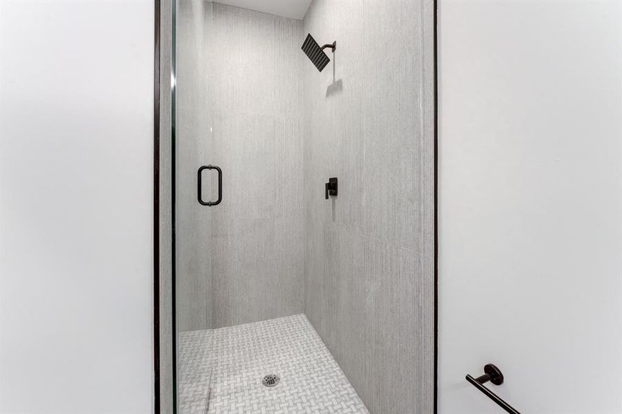 Gorgeous black accented shower with neutral toned tiling.