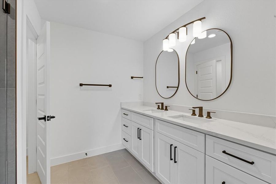 Bathroom featuring double vanity and light tile patterned floors