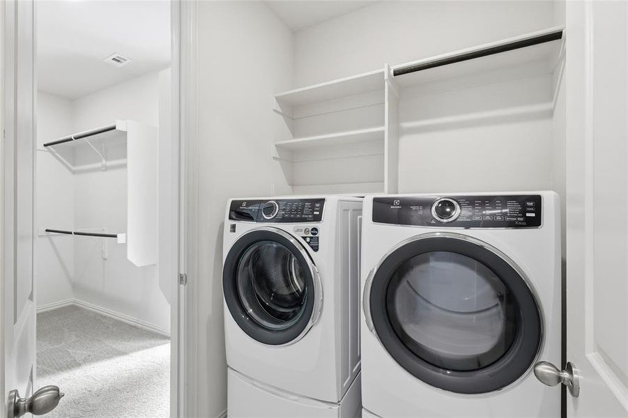 Laundry area with light colored carpet and washing machine and clothes dryer Laundry area with light colored carpet and washing machine and clothes dryer