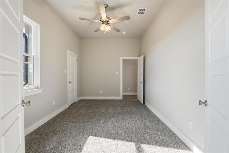 Unfurnished bedroom with carpet and a ceiling fan