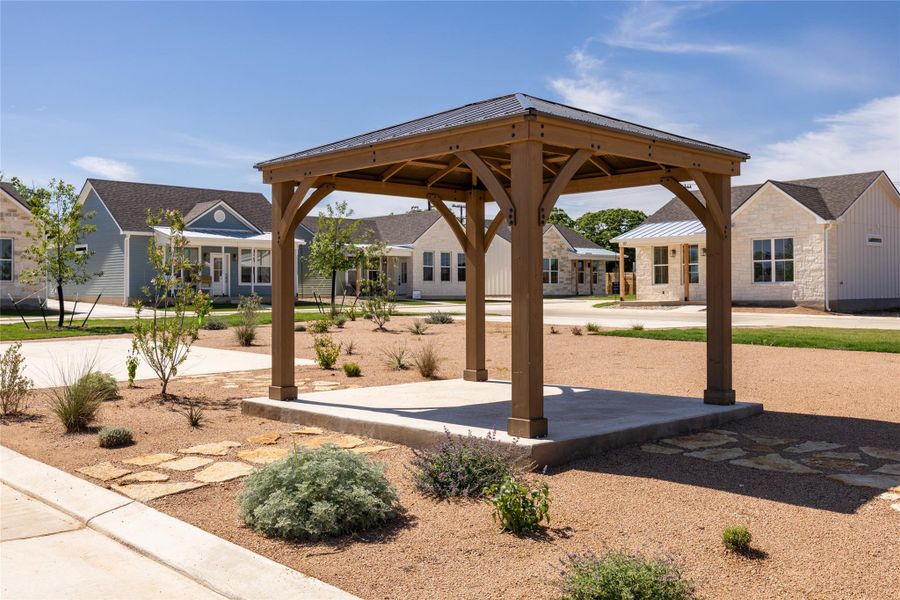 A quaint gazebo offers a charming outdoor retreat amidst a thoughtfully landscaped community setting.