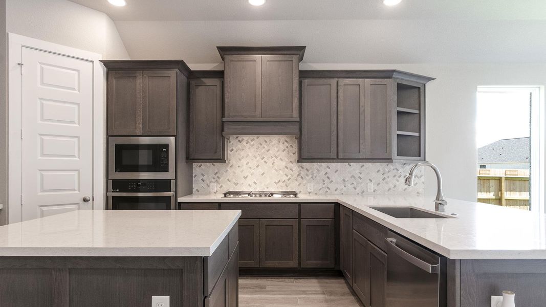 Kitchen featuring light countertops, stainless steel appliances, recessed lighting, light wood finished floors, and a peninsula