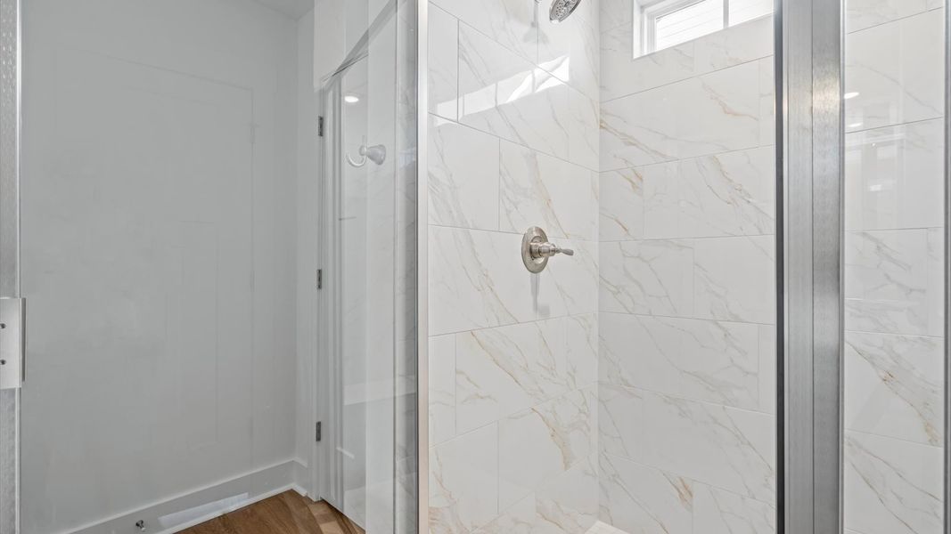 Superior en-suite primary bathroom with stylish dual vanity and tiled walk-in shower crafted with high standards in mind