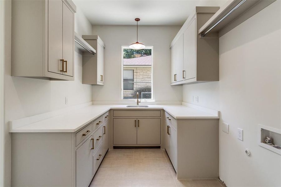 Kitchen with light countertops, light tile patterned floors, and pendant lighting Kitchen with light countertops, light tile patterned floors, and pendant lighting