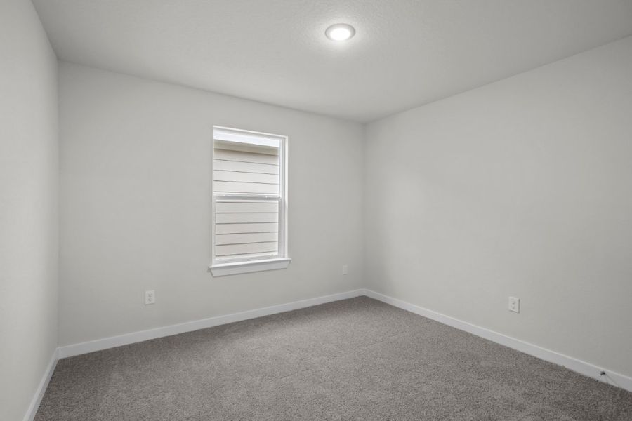 A room with a window and a carpet.