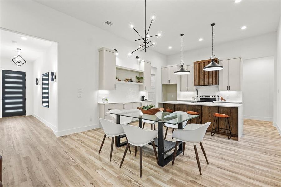Dining room with a chandelier, light wood-type flooring, and recessed lighting