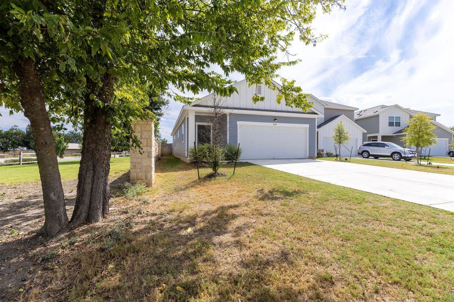 View of front of house featuring concrete driveway, a front lawn, a garage, and board and batten siding View of front of house featuring concrete driveway, a front lawn, a garage, and board and batten siding