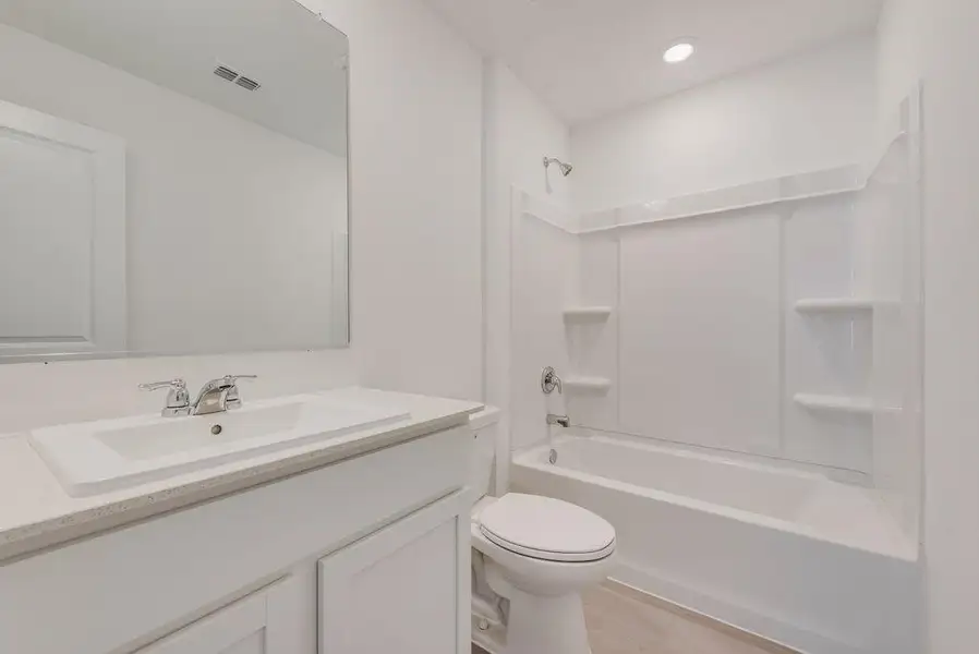 Bathroom featuring shower / bathtub combination, vanity, and recessed lighting