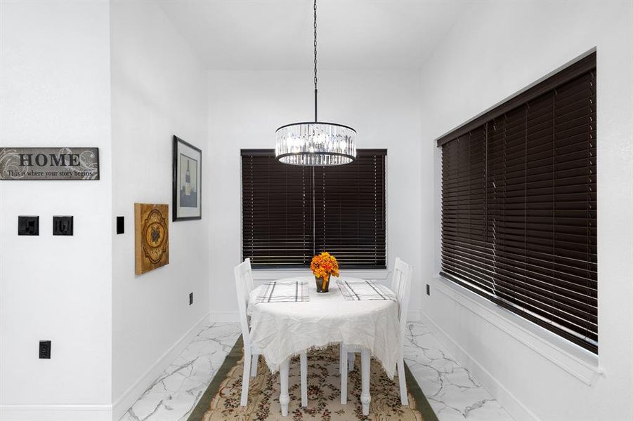 Dining room featuring marble finish flooring and a chandelier