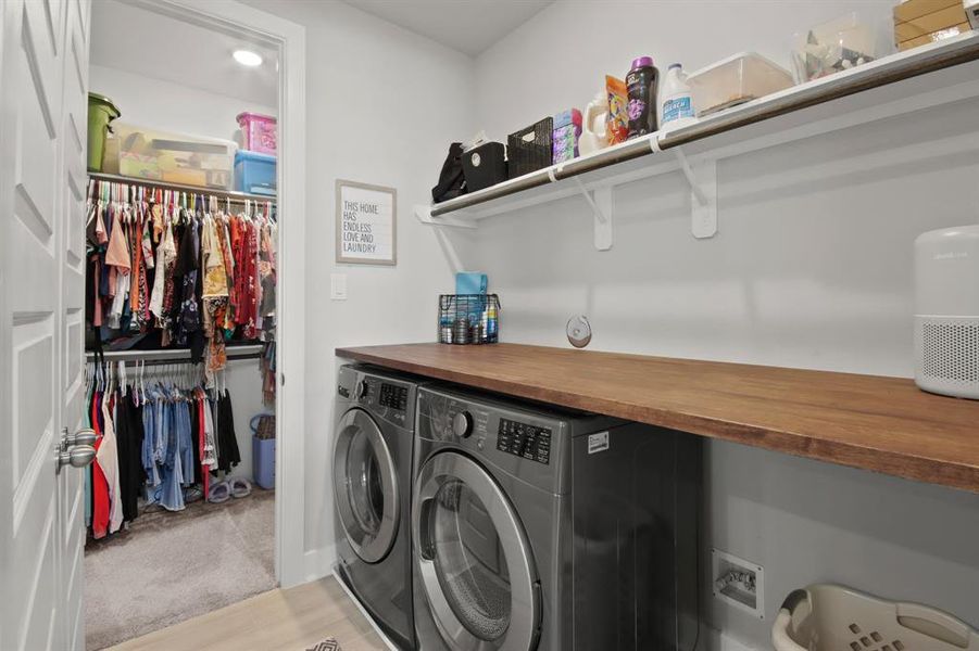 Laundry room with custom shelving leads to primary closest for an added convenience.