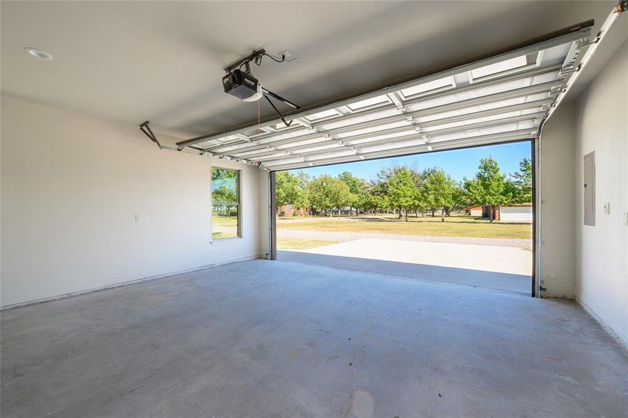 Garage featuring a garage door opener and electric panel