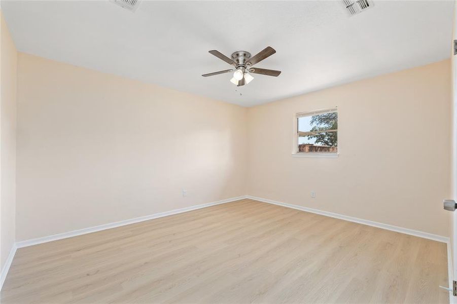 Spare room with light wood finished floors and ceiling fan