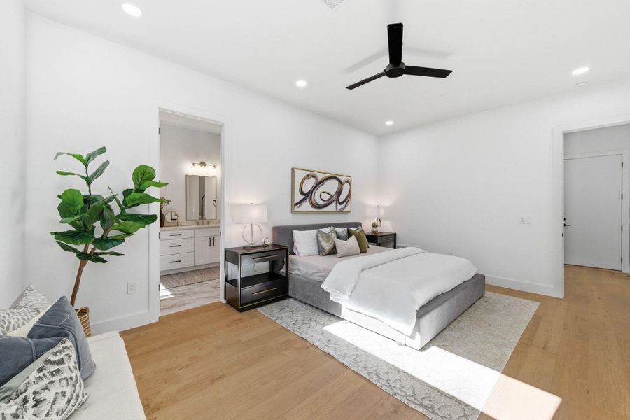 Primary bedroom featuring light wood-type flooring, recessed lighting, and ceiling fan, natural light plus located downstairs with access to private backyard