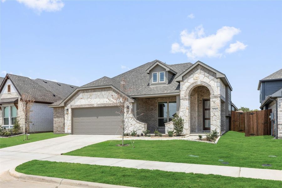 Single-story home with brick and stone exterior, arched entryway, two-car garage, and green front lawn. Single-story home with brick and stone exterior, arched entryway, two-car garage, and green front lawn.