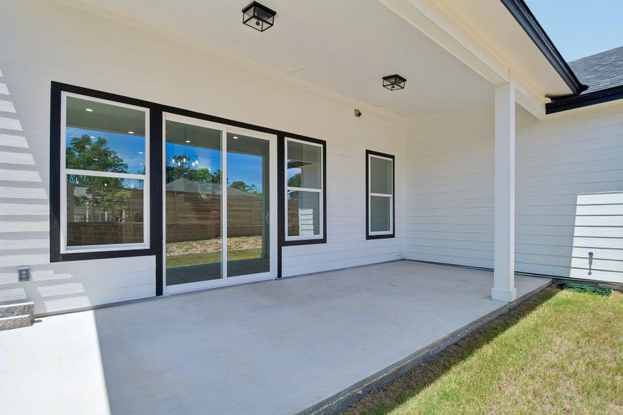 A covered concrete patio provides a comfortable outdoor retreat overlooking the backyard. A covered concrete patio provides a comfortable outdoor retreat overlooking the backyard.