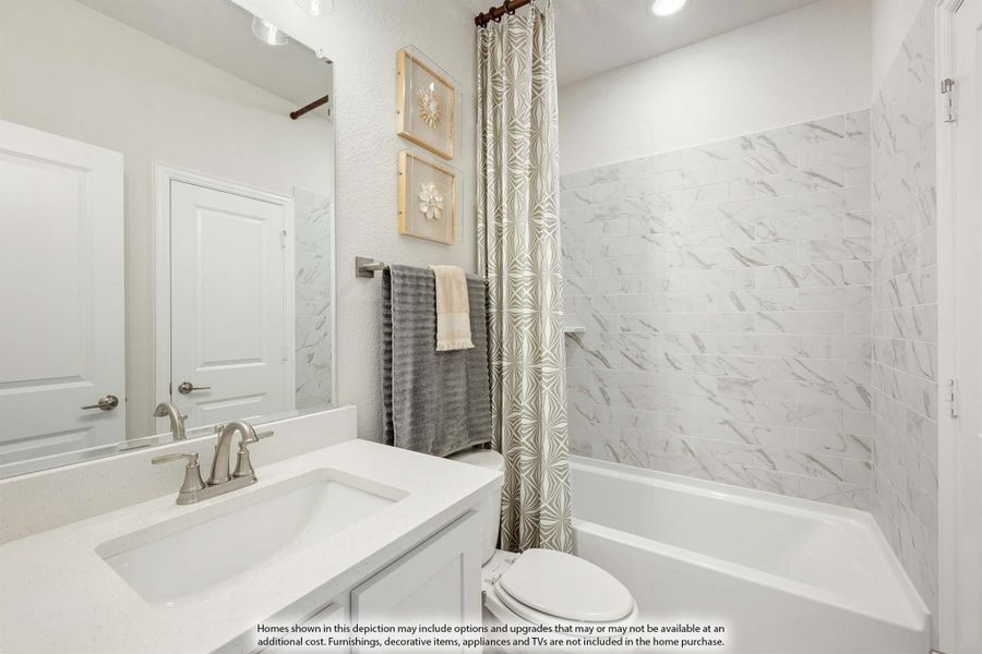 Bathroom with white vanity, marble-style tile tub surround, and patterned shower curtain