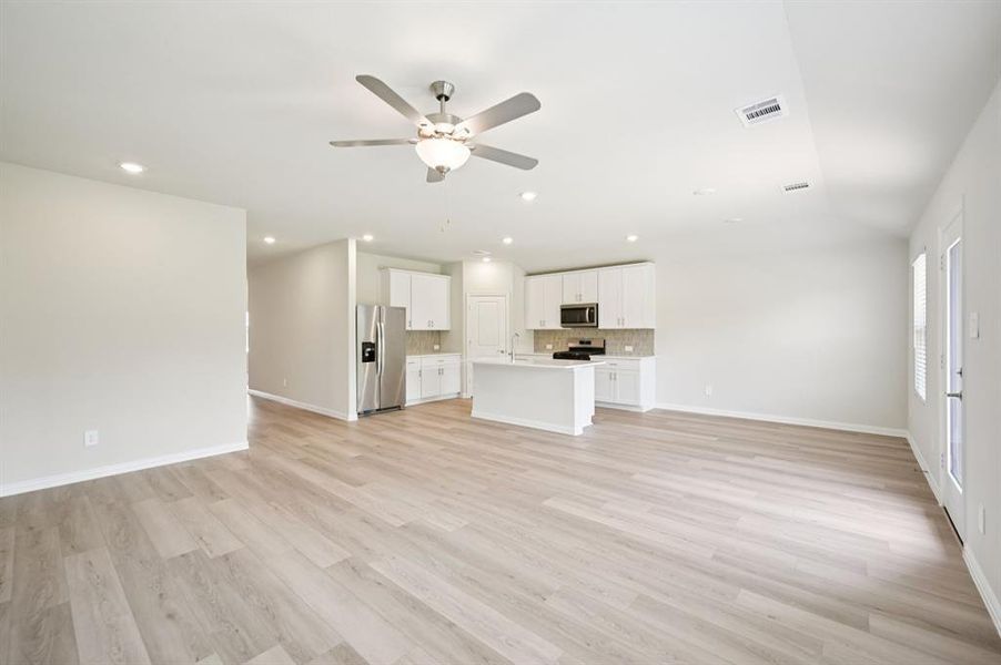 Living room featuring ceiling fan, light wood-style floors, lofted ceiling, and recessed lighting