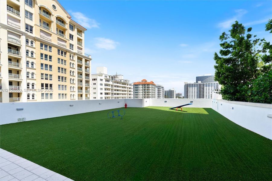 Rooftop terrace featuring synthetic turf, perimeter masonry walls, and integrated wall-mounted lighting