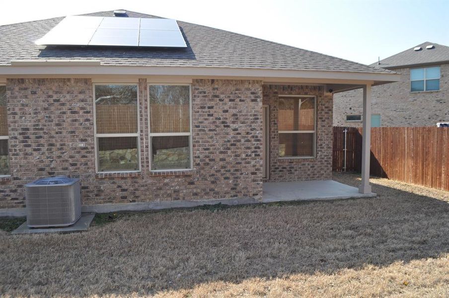 Back of property featuring solar panels, a patio, and central air condition unit