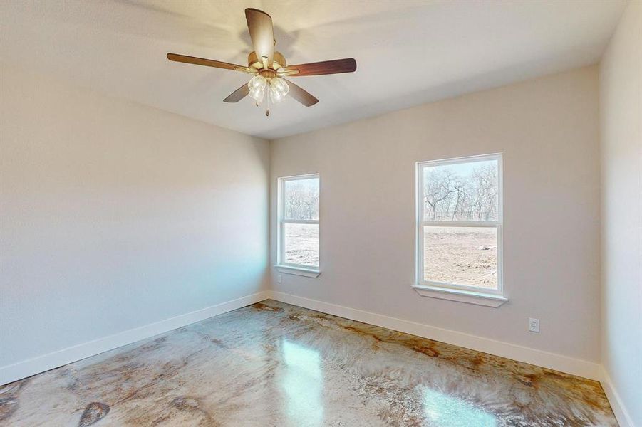 Unfurnished room with concrete floors and ceiling fan