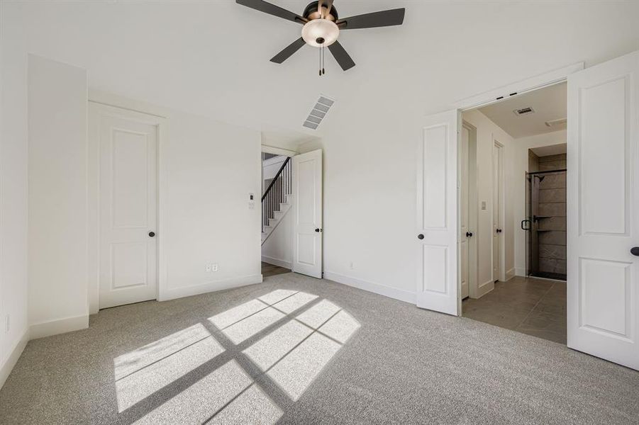 Unfurnished bedroom with light colored carpet and ceiling fan