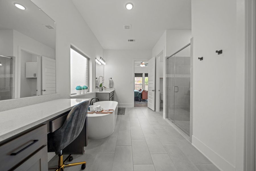 Freestanding tub under frosted window brings both privacy and natural light. Dual vanities and storage add everyday convenience. Freestanding tub under frosted window brings both privacy and natural light. Dual vanities and storage add everyday convenience.