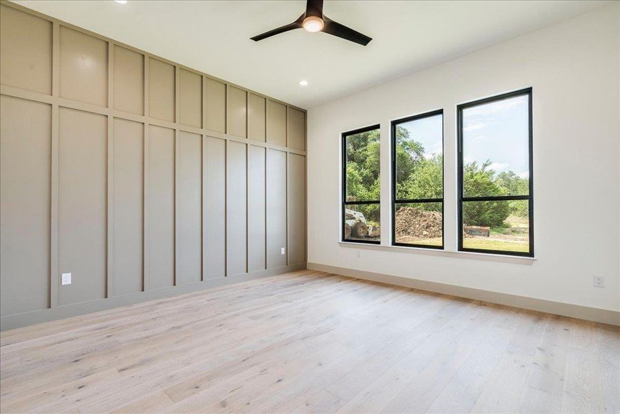 Board and batten accent wall frames a generously sized room with abundant natural light.