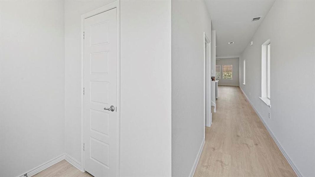Corridor featuring light wood finished floors and baseboards