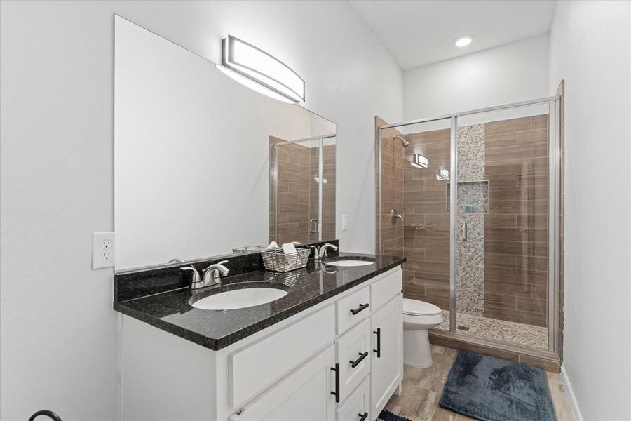 Bathroom featuring a stall shower and double vanity