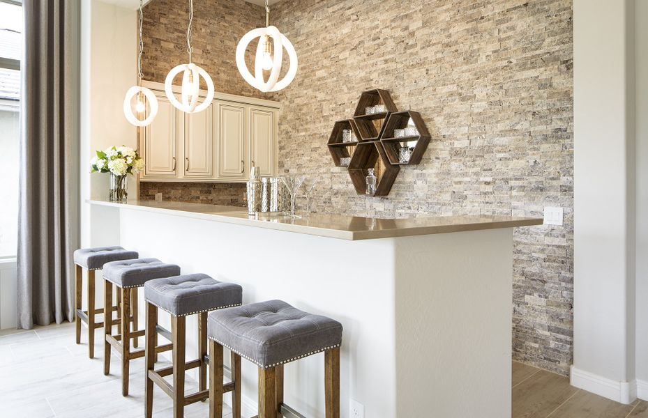 Wet bar area with built in fridge and bar-top seating