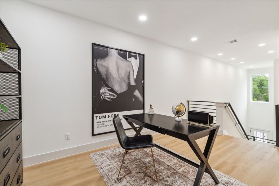 Overlooking the grand entry, this upstairs flex space is bathed in natural light from high windows—creating a bold and bright area to work, unwind, or showcase your style.