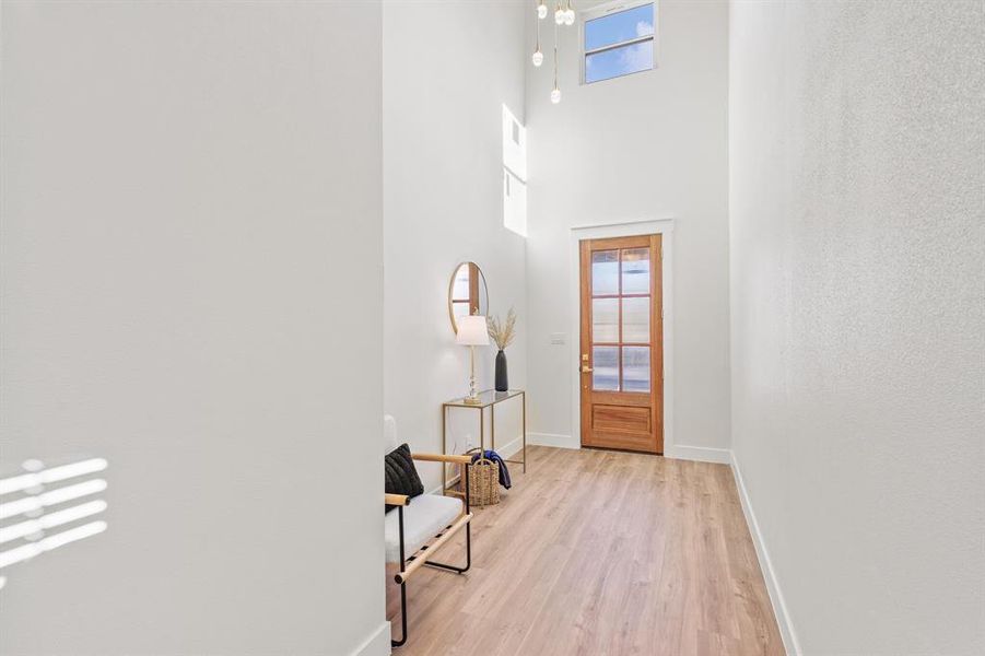 Foyer with a towering ceiling and light wood-type flooring