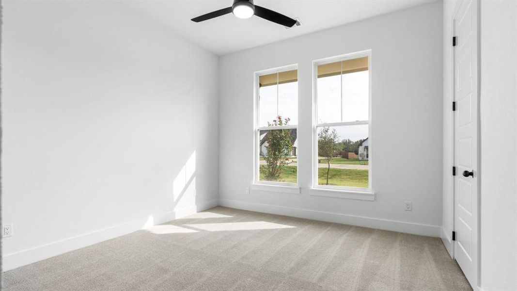 Carpeted empty room featuring ceiling fan