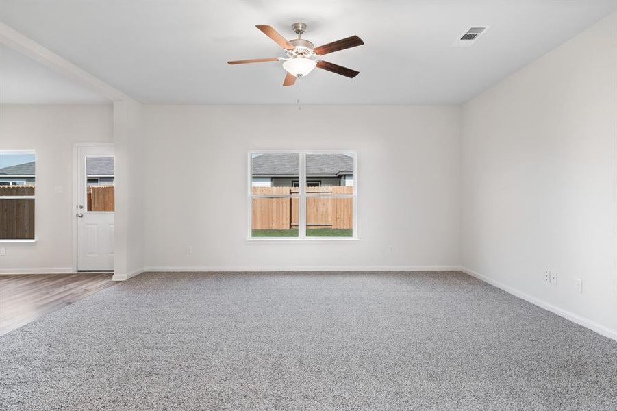 Carpeted spare room with ceiling fan