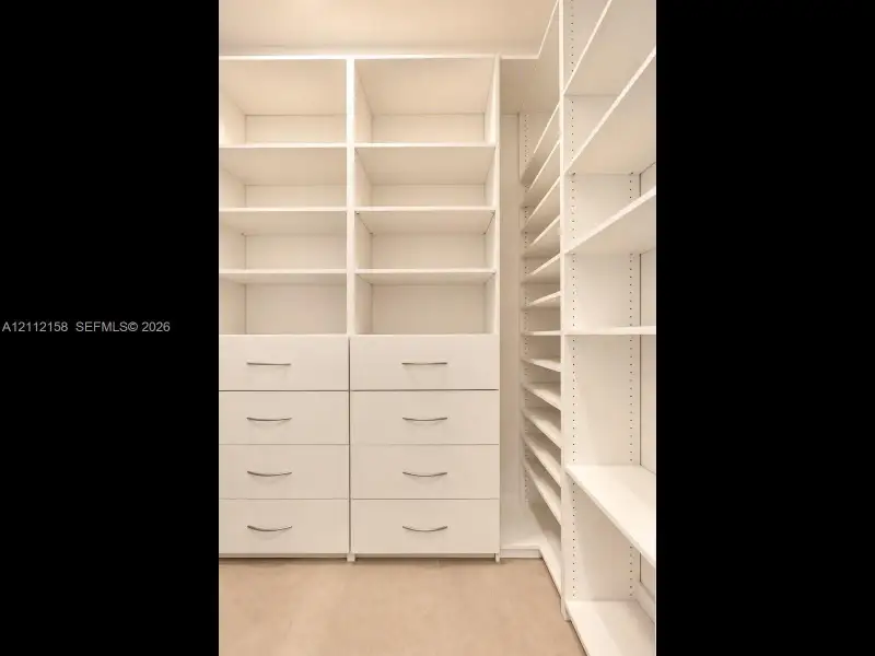 Custom floor-to-ceiling built-in storage with integrated drawers and polished hardware — a place for everything