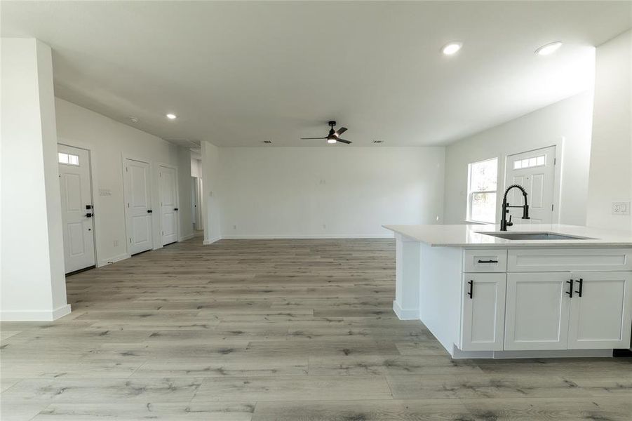 Kitchen with ceiling fan, sink, and white cabinetry