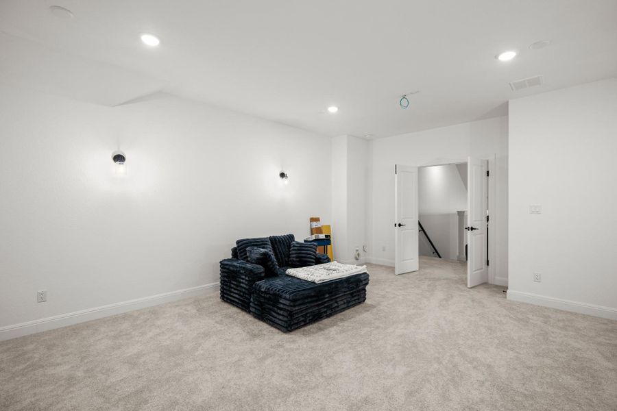 Living area with light carpet and recessed lighting Living area with light carpet and recessed lighting