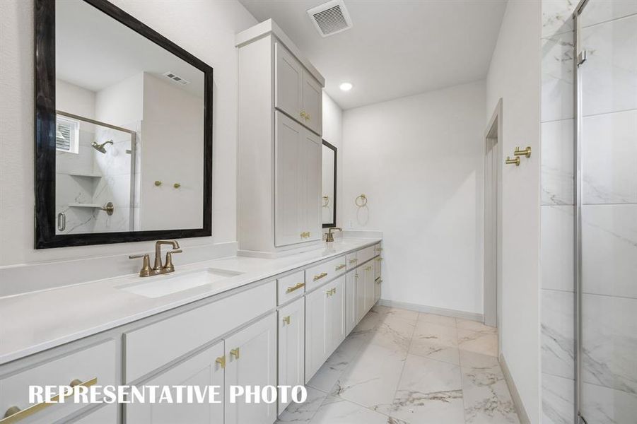 Featuring fantastic storage and dual vanities, this owner's bath offers ample room for two!  REPRESENTATIVE PHOTO