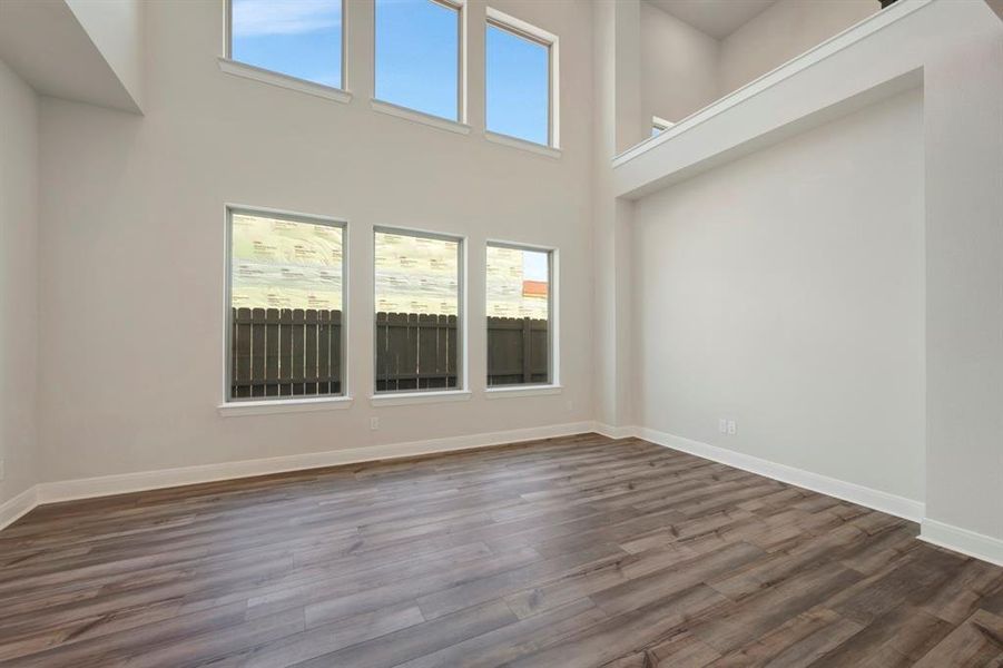 Unfurnished living room featuring dark wood-style floors and a high ceiling