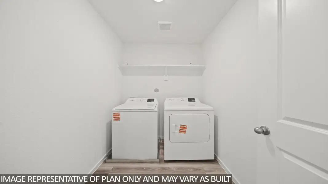 Dedicated laundry area featuring wood-finish flooring, white walls, and a white overhead shelf