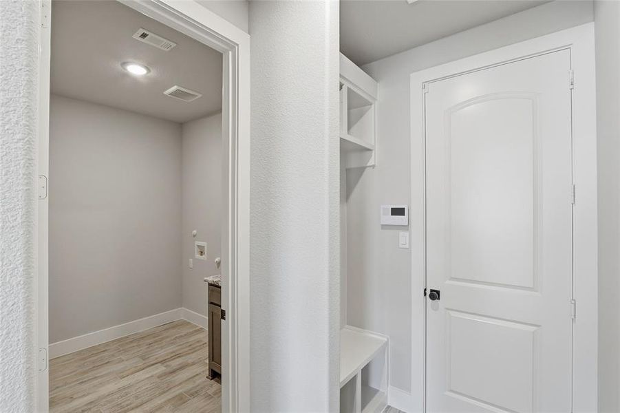 Mudroom with light wood-style floors and baseboards