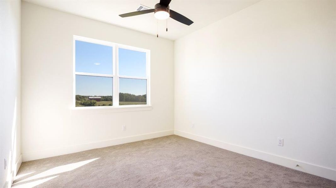 Unfurnished room with ceiling fan and light colored carpet