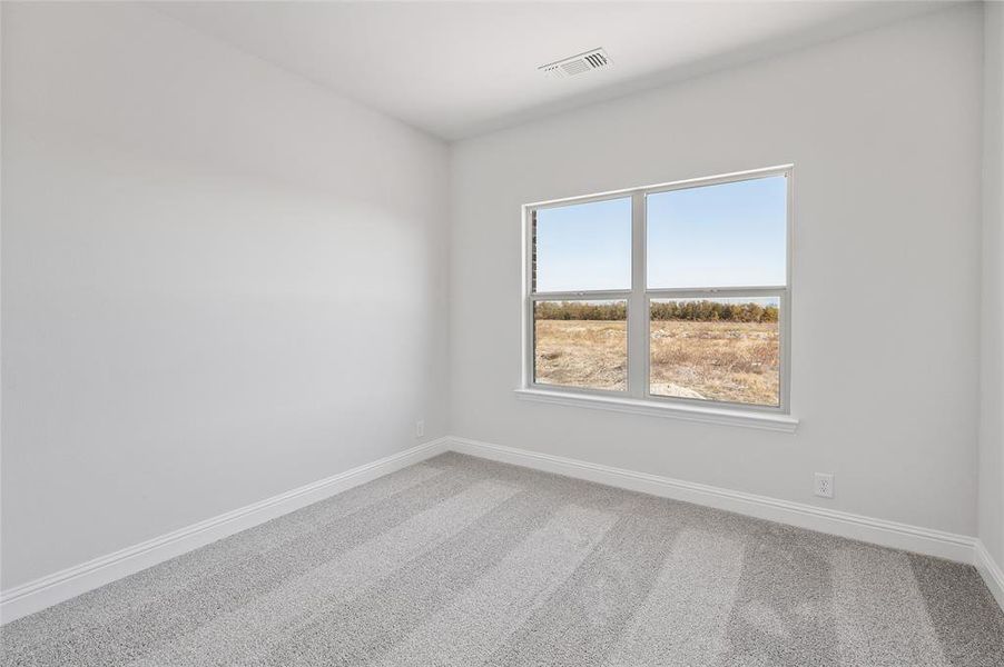 Spare room with light carpet and baseboards