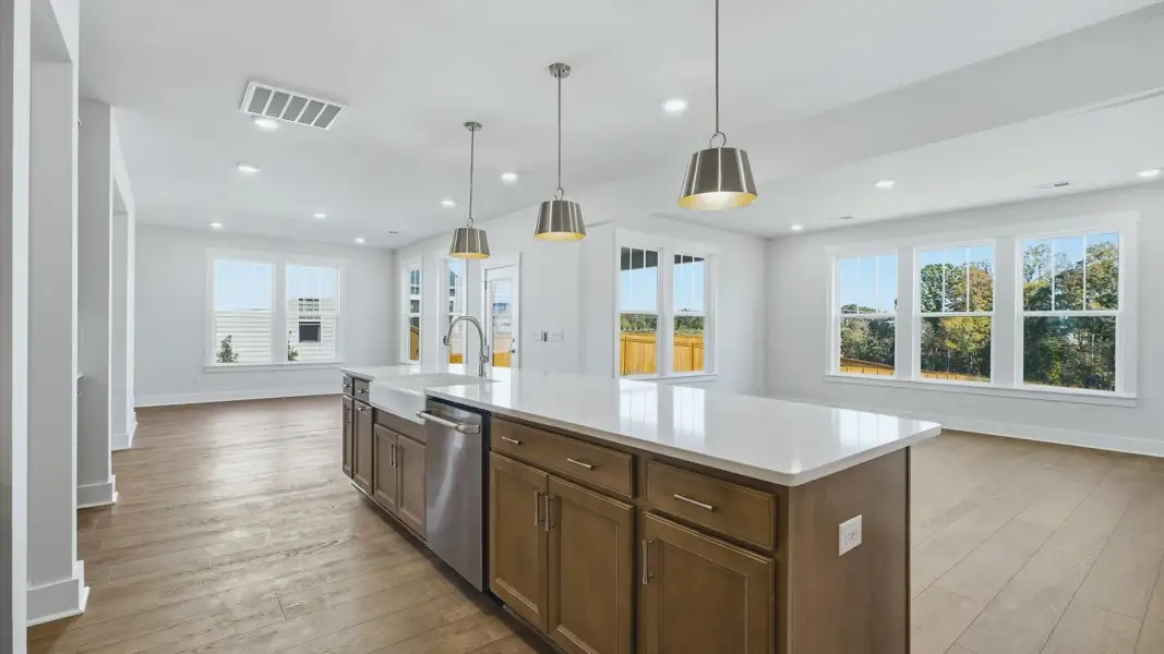 Exclusive kitchen design with large island, pendant lights, and tasteful finishes throughout by DRB Homes Exclusive kitchen design with large island, pendant lights, and tasteful finishes throughout by DRB Homes