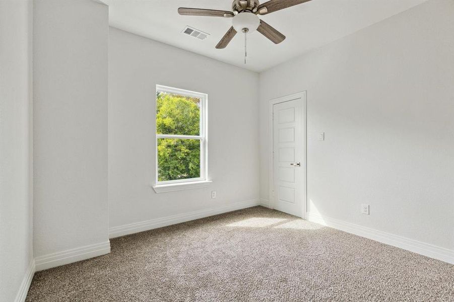 Carpeted spare room featuring ceiling fan