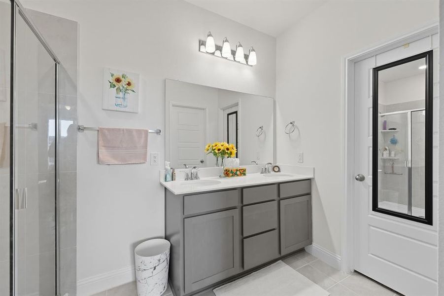 Bathroom with a shower stall, double vanity, and light tile patterned floors Bathroom with a shower stall, double vanity, and light tile patterned floors