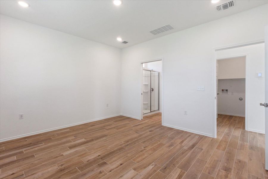 Unfurnished bedroom featuring a walk in closet, recessed lighting, and light wood-style tile flooring