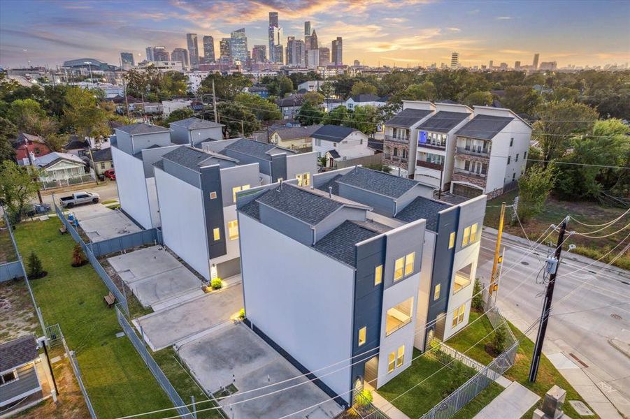 This aerial shot beautifully showcases the modern Hardy Skyline community with its private driveways, individual units, and stunning proximity to downtown. The rooftop decks offer unparalleled views of the skyline, making it an ideal location for urban living. You can also see the easy access to green spaces and the community dog park, offering a perfect balance of city life and outdoor relaxation.