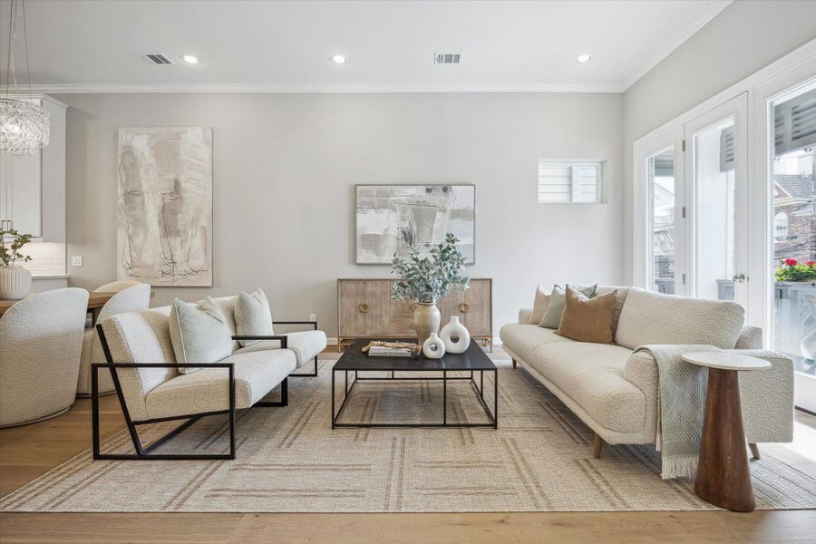 Living room with European engineered white oak flooring, high ceilings, and recessed lighting. Double French doors open to a covered balcony.